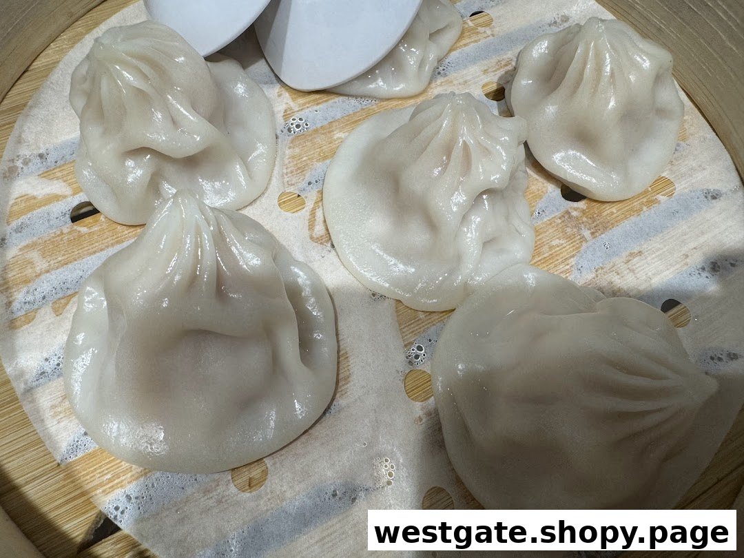 Freshly steamed soup dumplings (xiao long bao) in a bamboo steamer.