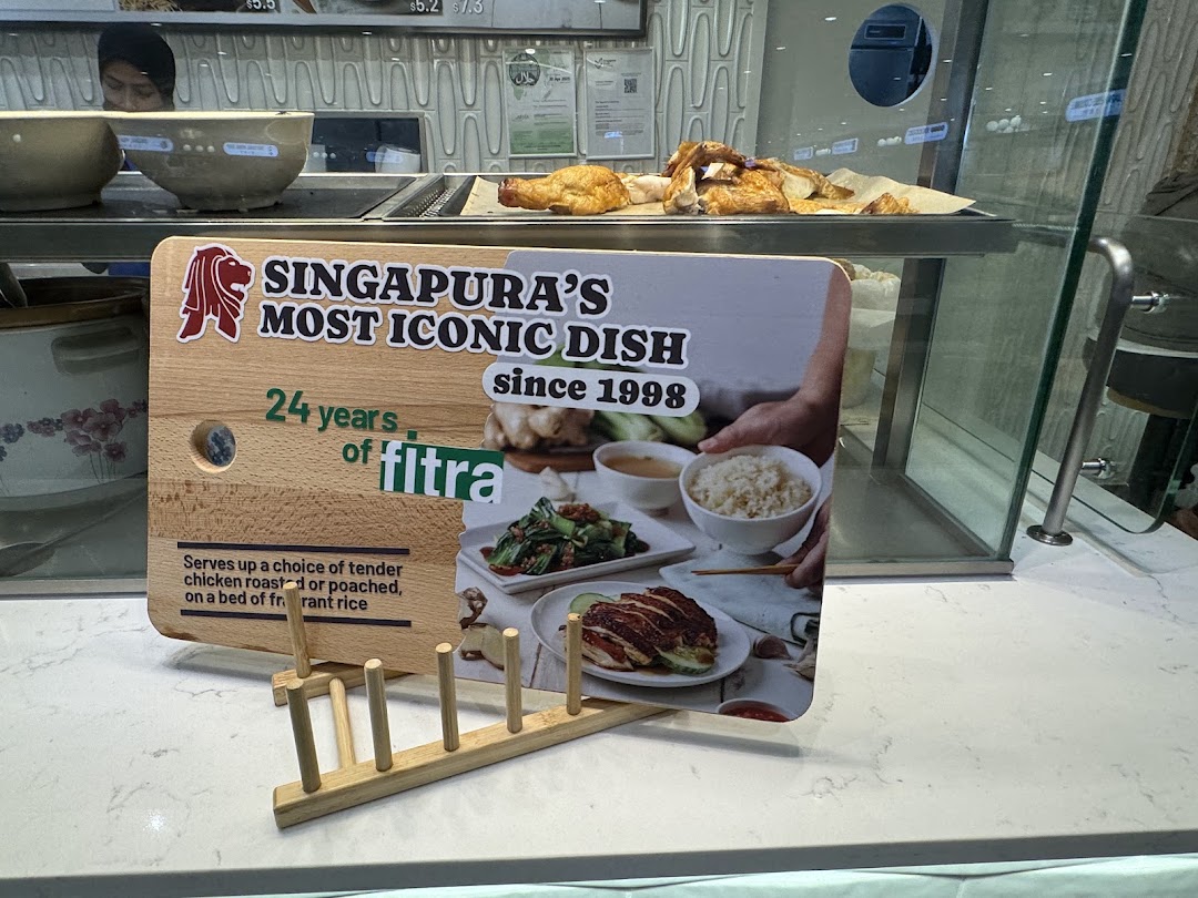 A promotional sign for an iconic chicken dish at a food stall, featuring roasted chicken.