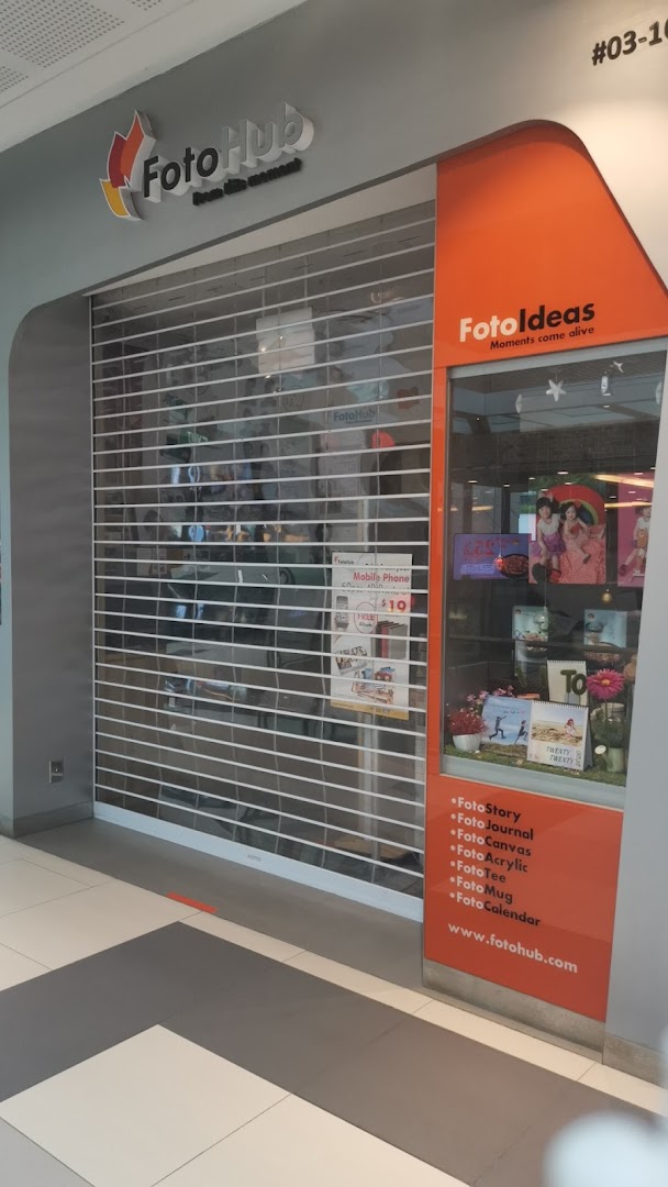 The closed shop front of FotoHub, a photo printing and personalized gift store, featuring its logo and display window.