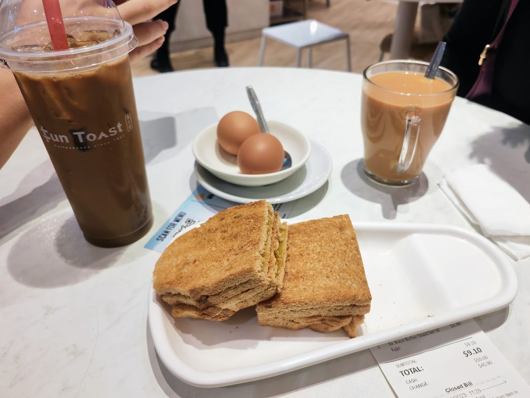 A table with Fun Toast's signature kaya toast, soft-boiled eggs, iced coffee, and milk tea.