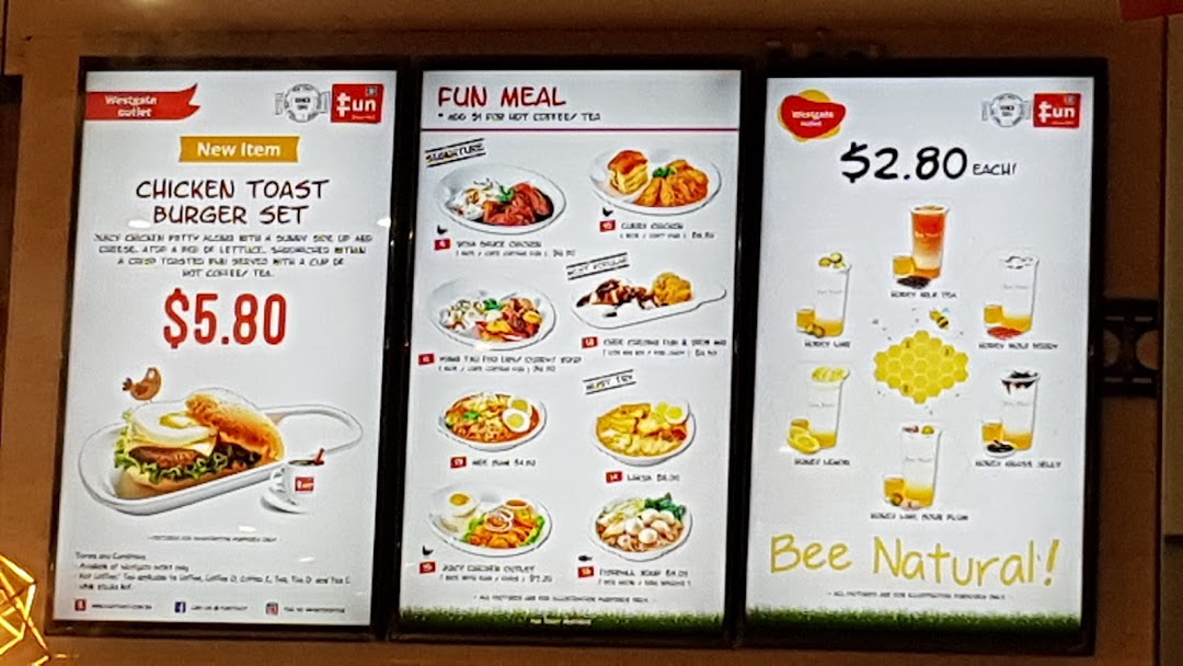 A brightly lit menu board for Fun Toast, showcasing new items, fun meals, and honey-based drinks.