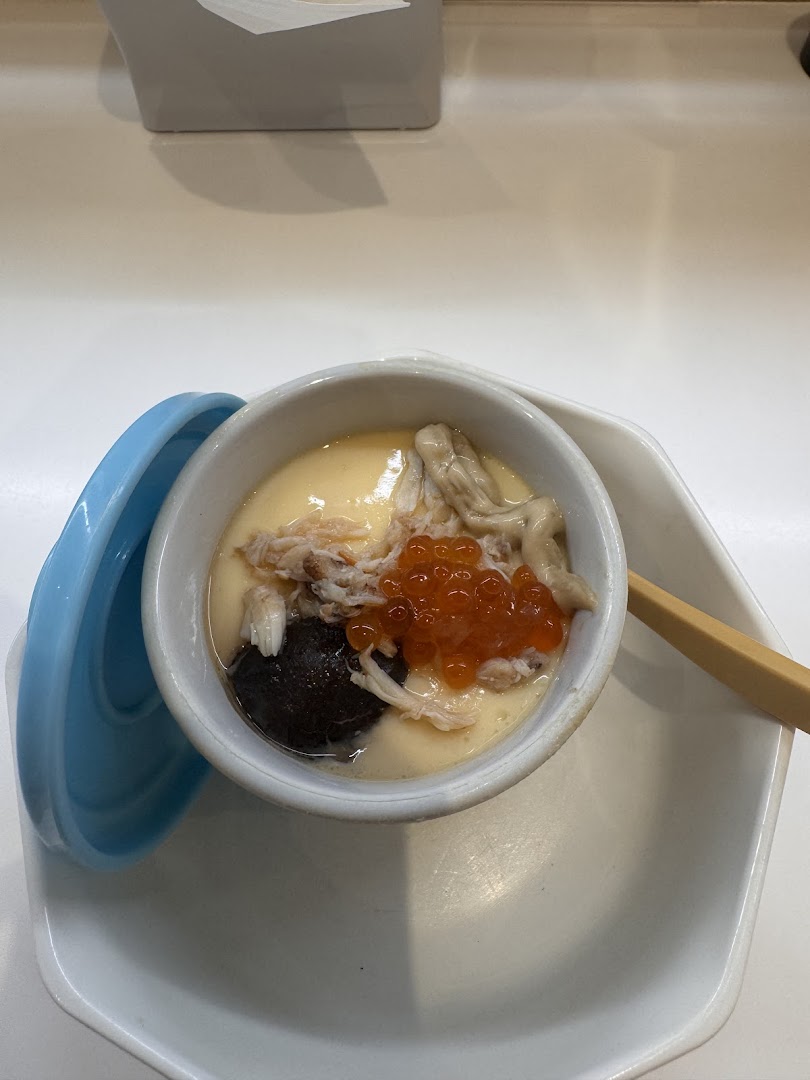 A close-up of a delicious Japanese steamed egg custard (Chawanmushi) with crab, mushroom, and salmon roe.