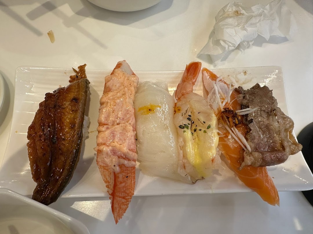 A white plate holds a variety of delicious sushi pieces, including eel, crab, and salmon.