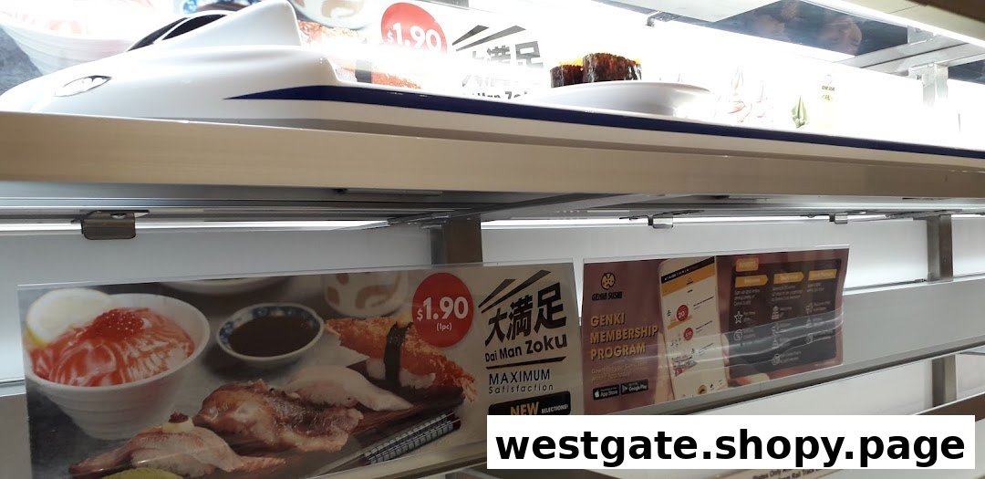 A sushi plate on a train delivery system at Genki Sushi, with promotional signs for membership and new items.