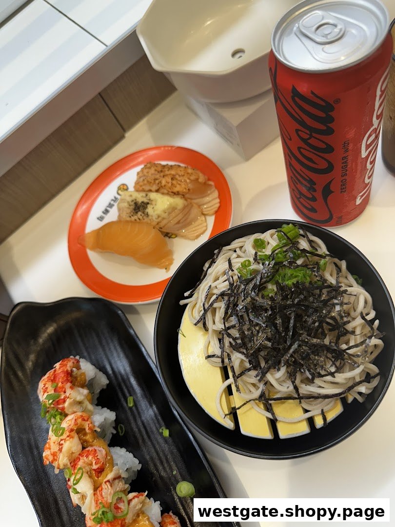 A table showcasing various sushi dishes, a noodle bowl, and a Coca-Cola can at Genki Sushi.