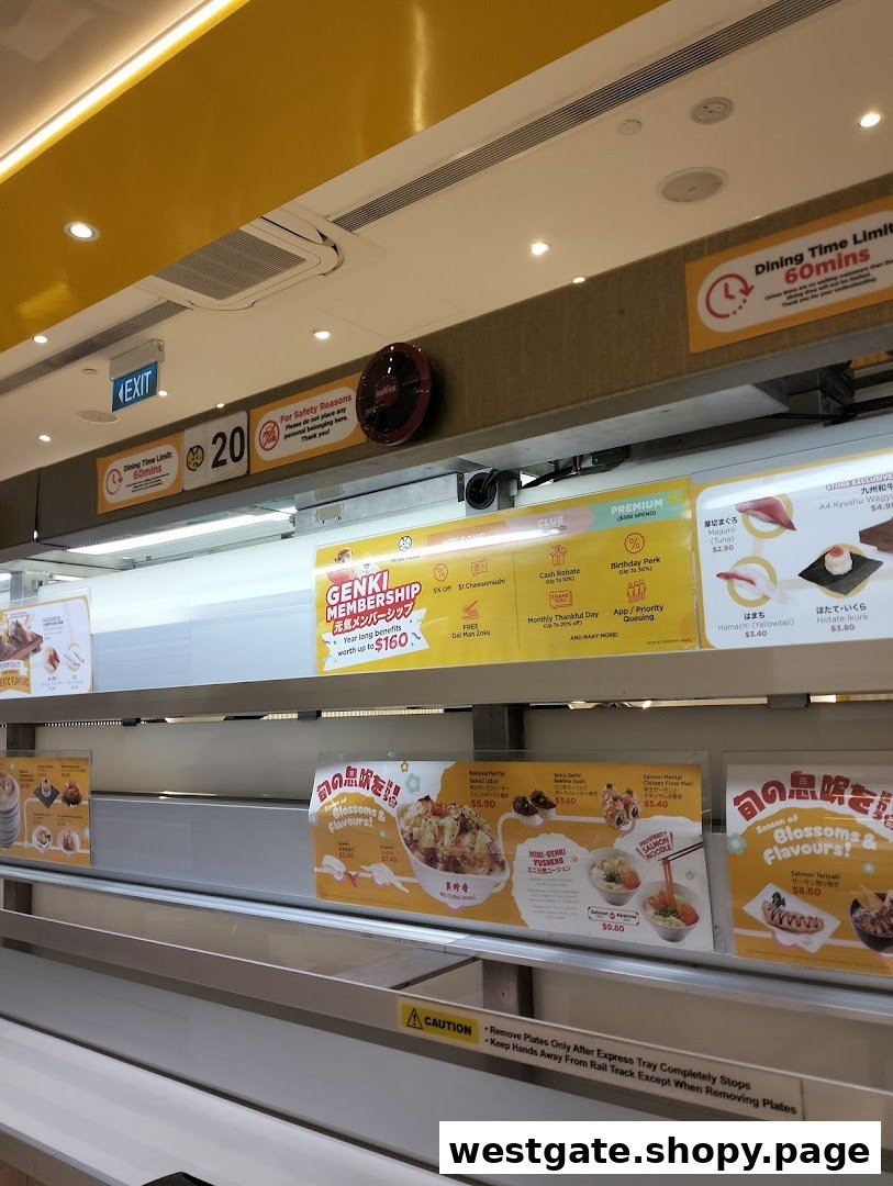 An interior view of Genki Sushi, showcasing its modern conveyor belt system and promotional displays.