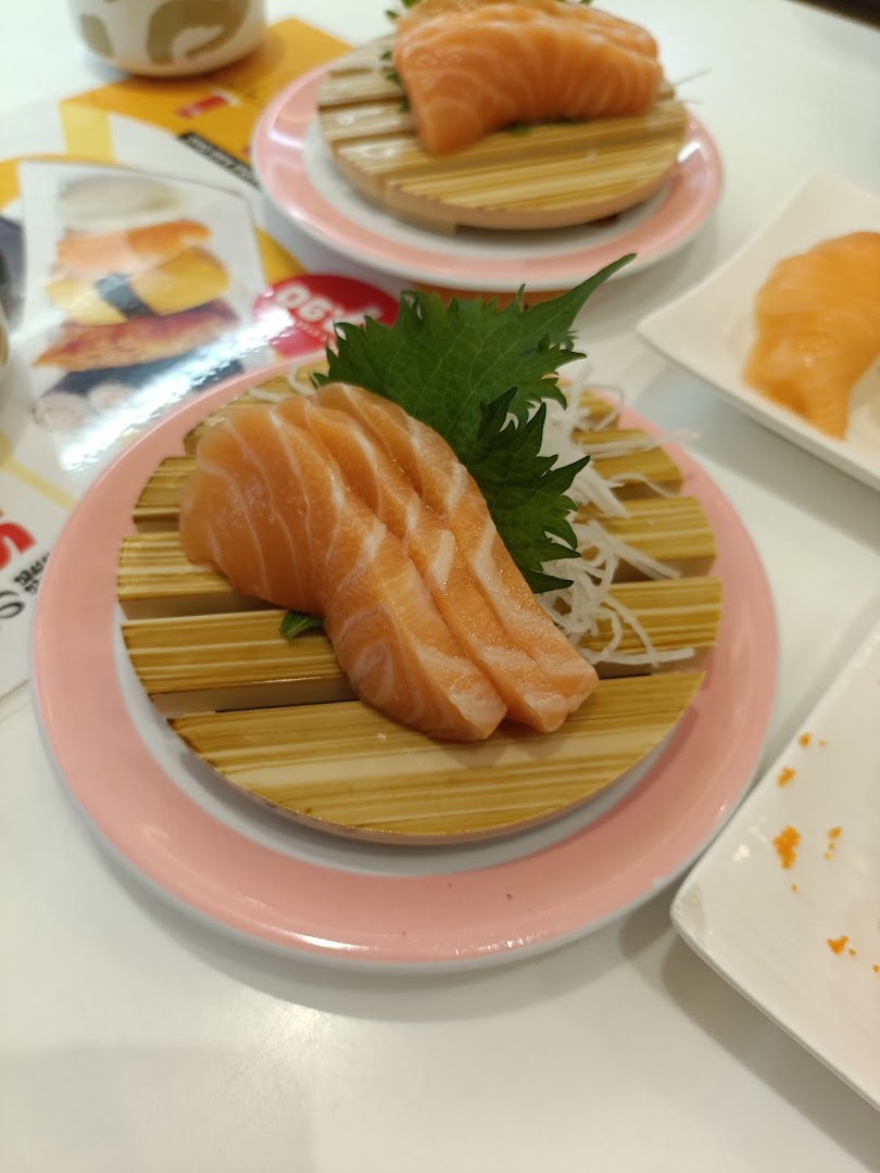 Fresh salmon sashimi and sushi served on pink plates at Genki Sushi.