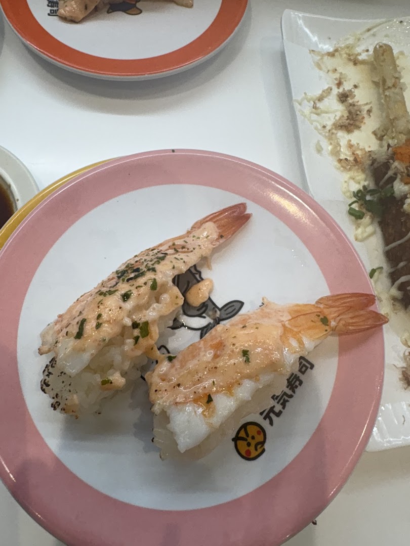 Two pieces of delicious shrimp sushi with sauce on a branded pink plate at Genki Sushi.