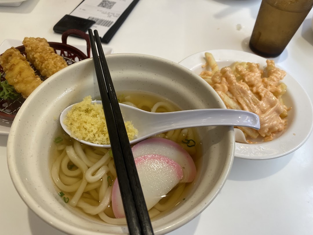 A table spread featuring a bowl of udon, crispy tempura, and fries with a creamy sauce.