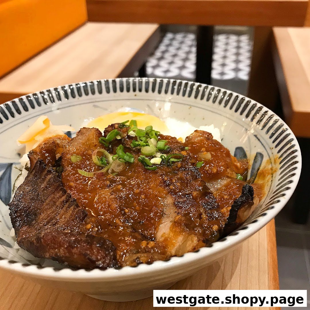 A close-up of a delicious Japanese rice bowl with grilled meat, sauce, and toppings.