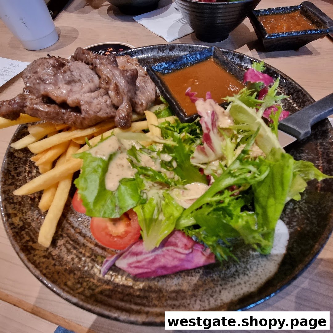 A delicious plate featuring sliced steak, golden french fries, and a fresh garden salad with dressing.