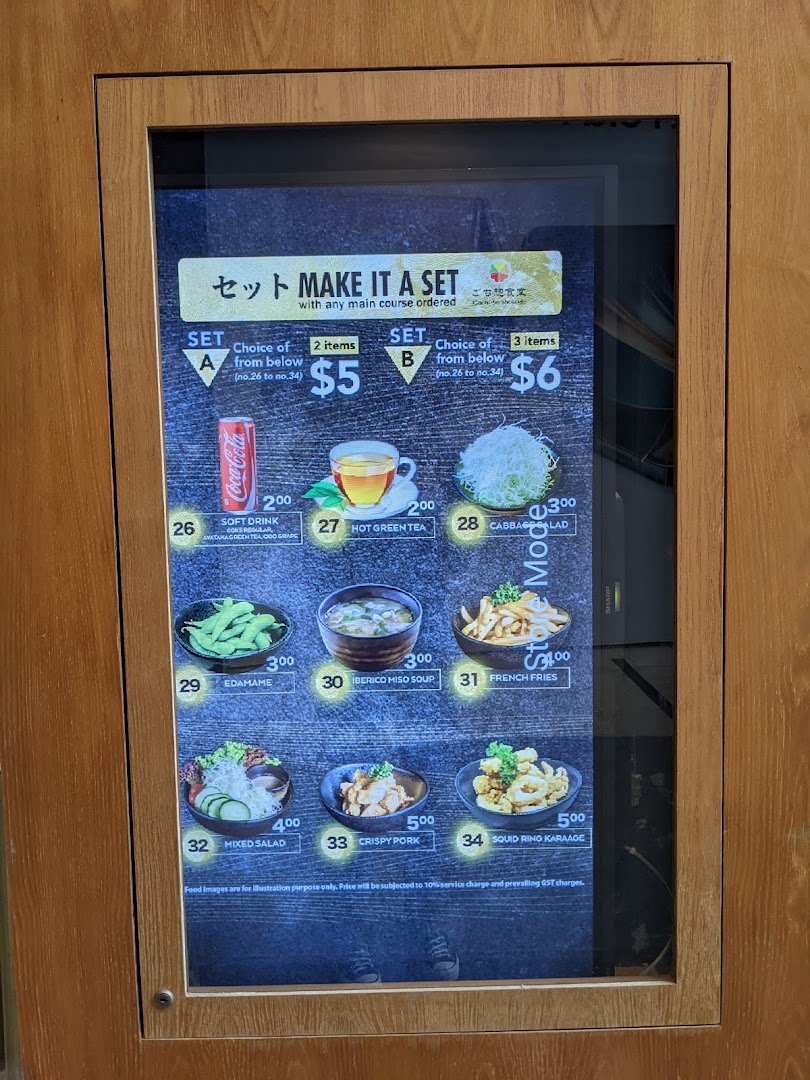 A digital menu board displaying set meal options and various side dishes with prices.