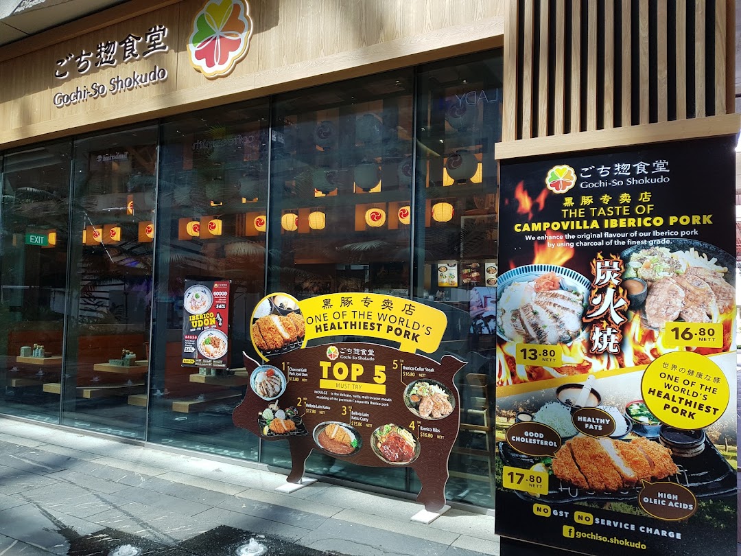 Exterior view of Gochi-So Shokudo, featuring its entrance, signage, and promotional displays for Iberico pork dishes.