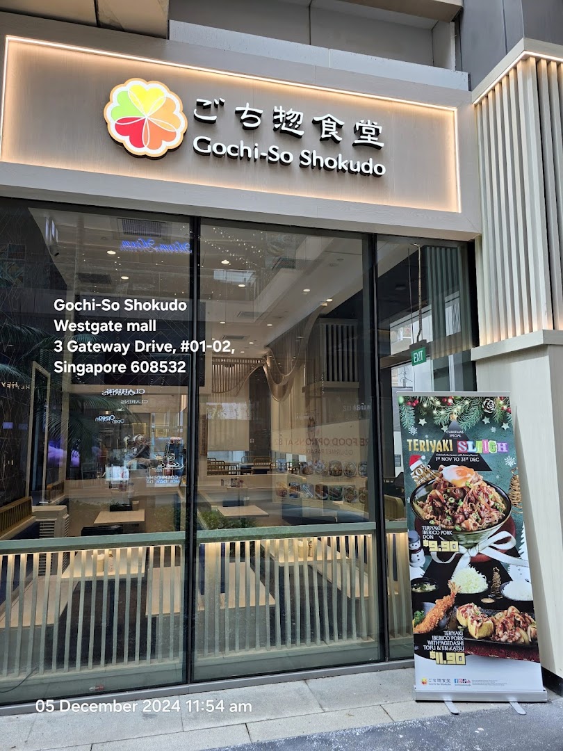 The inviting exterior of Gochi-So Shokudo, a Japanese restaurant, featuring its entrance, signage, and a promotional banner.