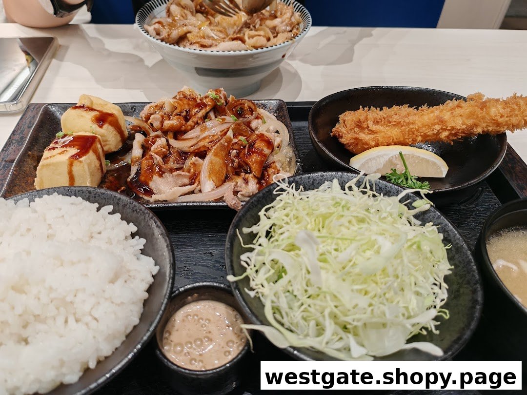 A Japanese meal set featuring sliced pork, fried shrimp, rice, shredded cabbage, and miso soup.