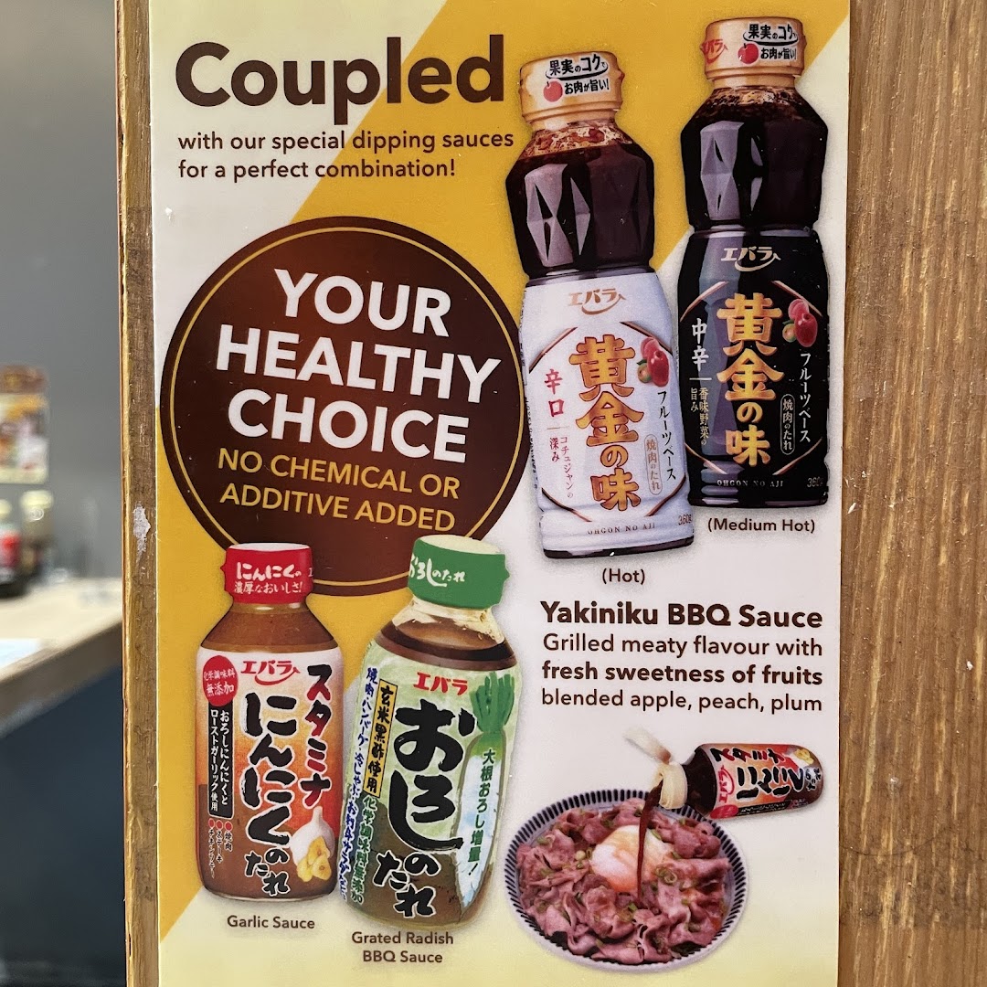 A display board showcasing various healthy dipping sauces, including Yakiniku BBQ, Garlic, and Grated Radish options.