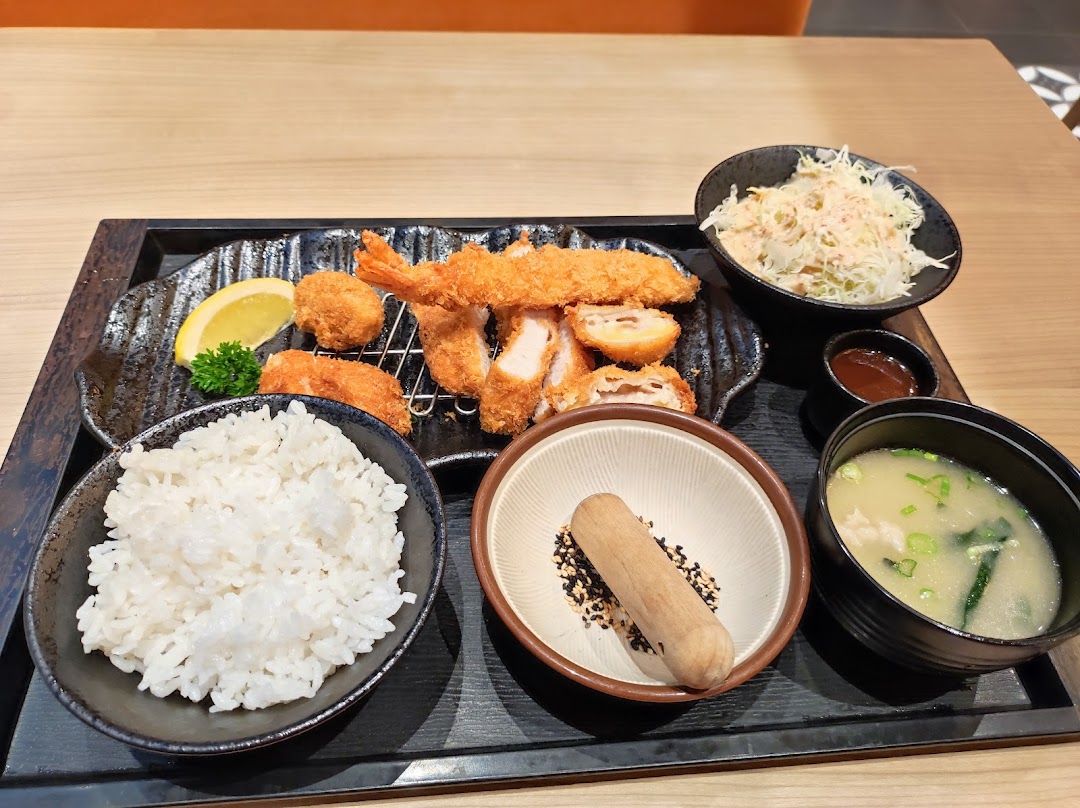 A delicious Japanese fried food set featuring tonkatsu, fried shrimp, rice, miso soup, and salad.