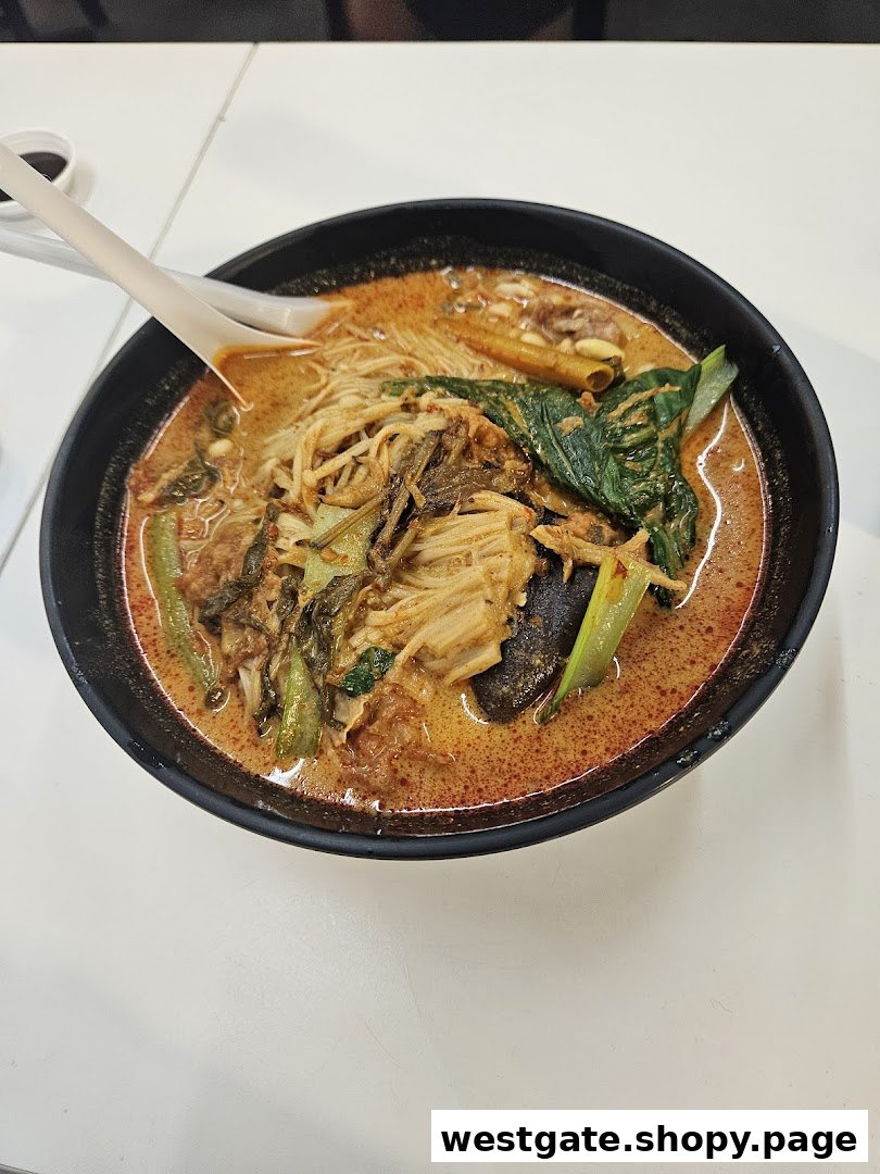 A vibrant bowl of spicy noodles with various vegetables and ingredients, served on a white table.