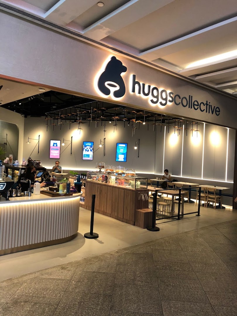 The inviting shopfront of Huggs Collective, featuring its prominent logo, counter, and comfortable seating area.