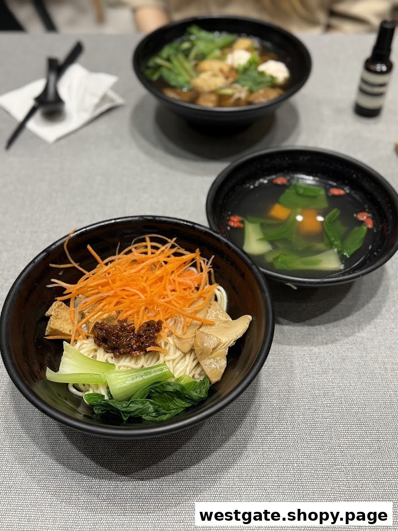 Three bowls of delicious plant-based meals, including noodles and soups, served on a table at Greendot.
