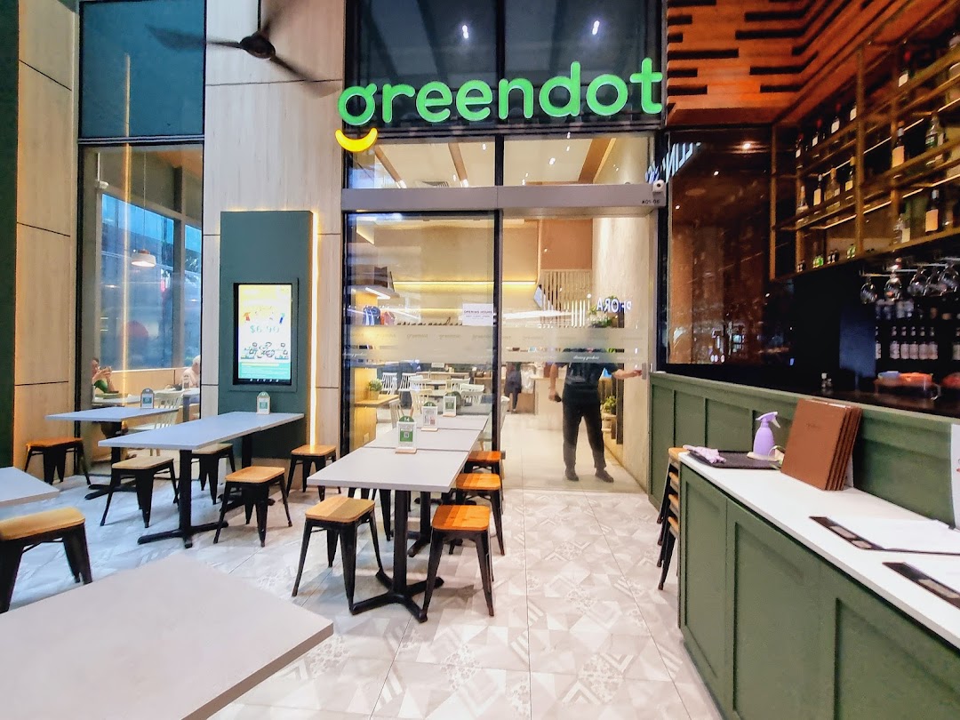 The exterior of Greendot Westgate features outdoor seating and a clear view into the modern vegetarian restaurant.