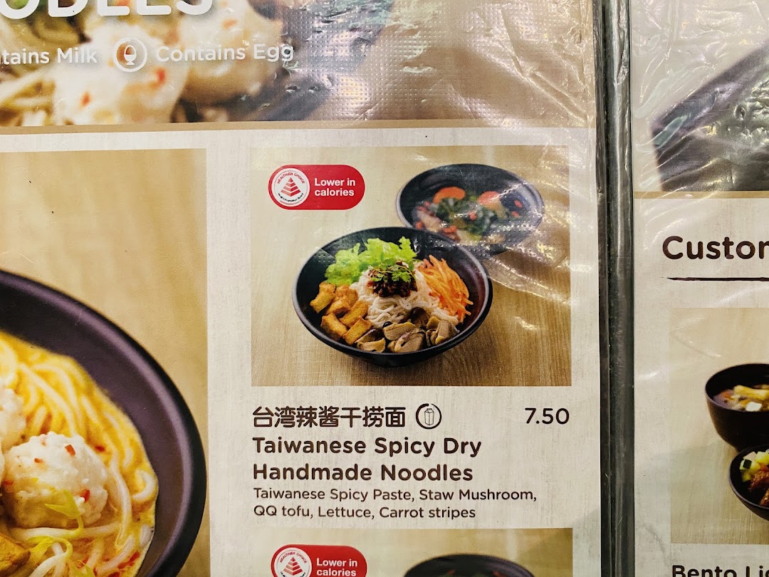 Close-up of Greendot's menu featuring Taiwanese Spicy Dry Handmade Noodles with ingredients and price.