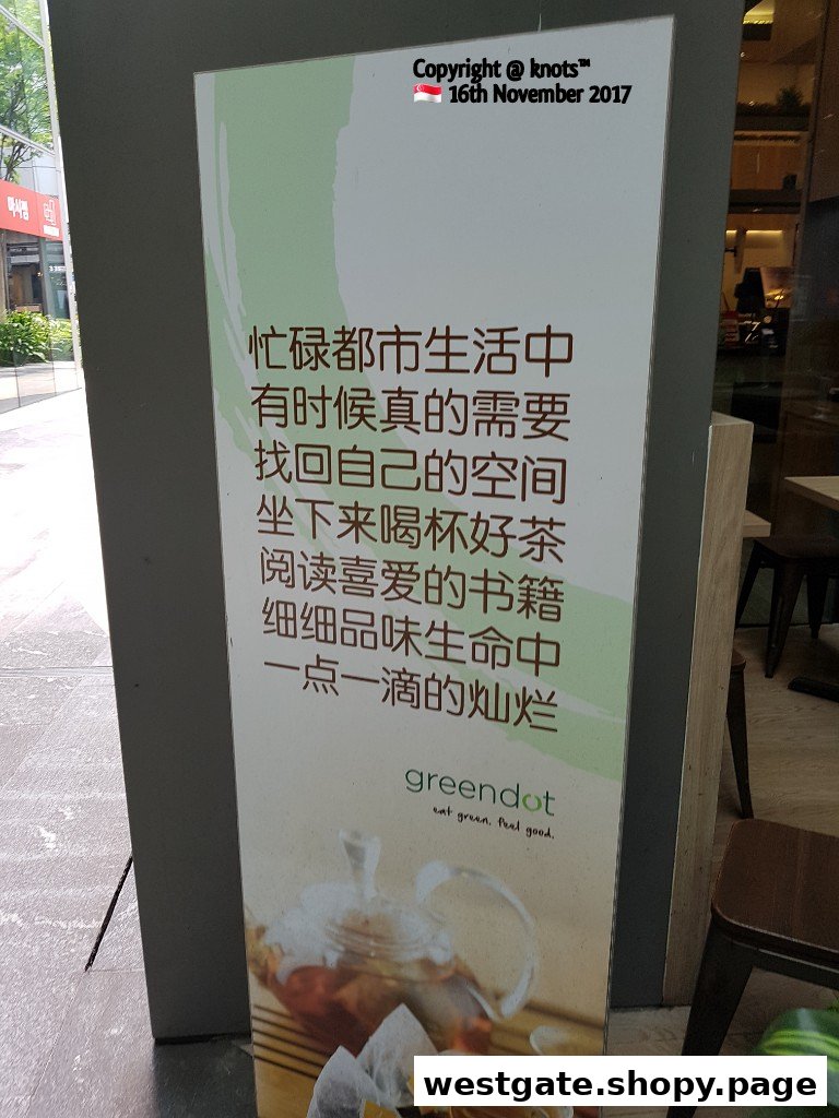 A Greendot signboard promoting relaxation with tea, books, and the 'eat green. feel good.' slogan.