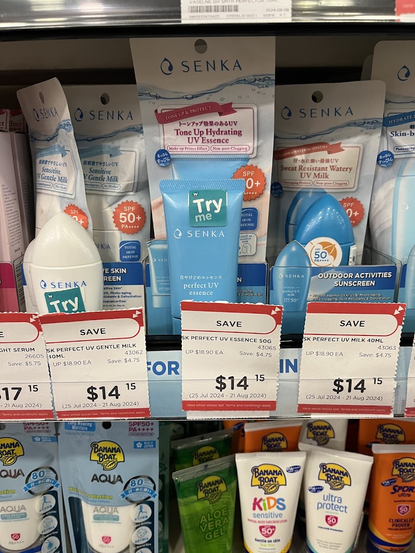 A shelf display featuring various Senka and Banana Boat sunscreens and skincare products with promotional pricing.