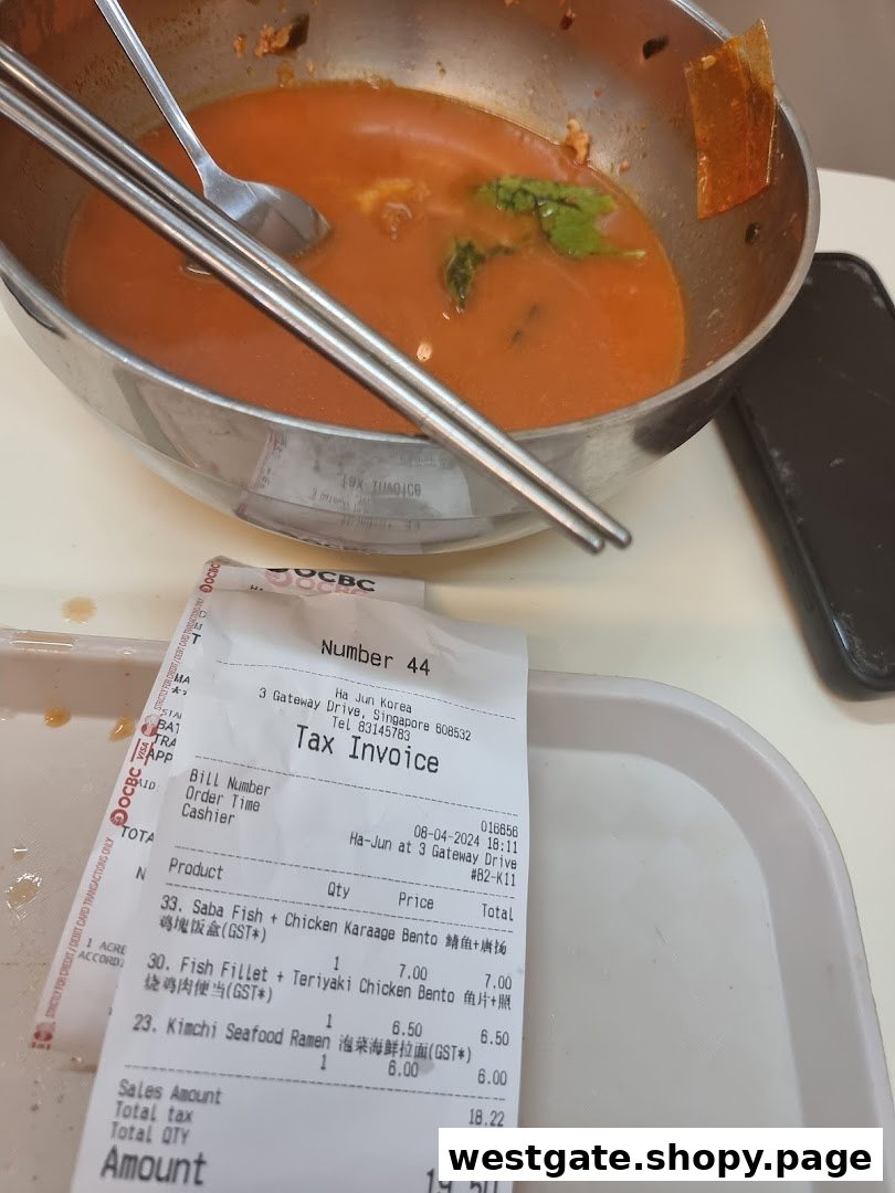 A partially eaten bowl of Korean food with chopsticks and a detailed receipt from Ha-Jun Westgate.
