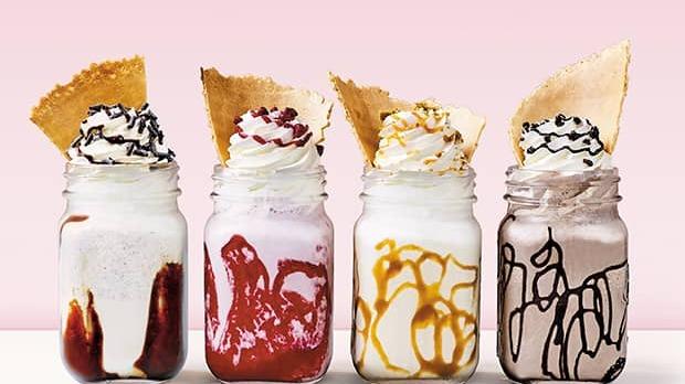 Four delicious Häagen-Dazs milkshakes or sundaes in jars, topped with whipped cream and wafers.