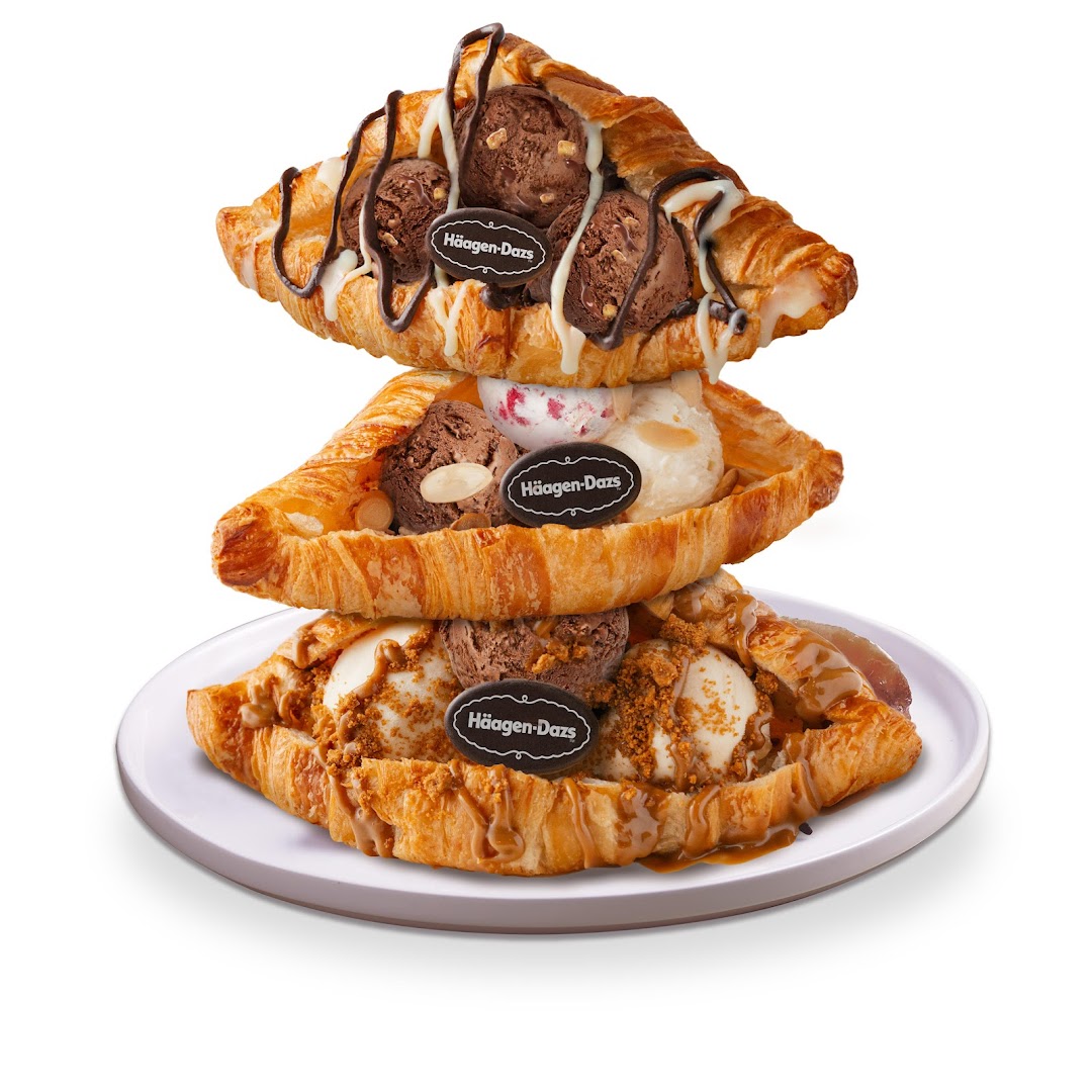 Stacked croissants filled with Häagen-Dazs ice cream, drizzled with sauces and toppings.