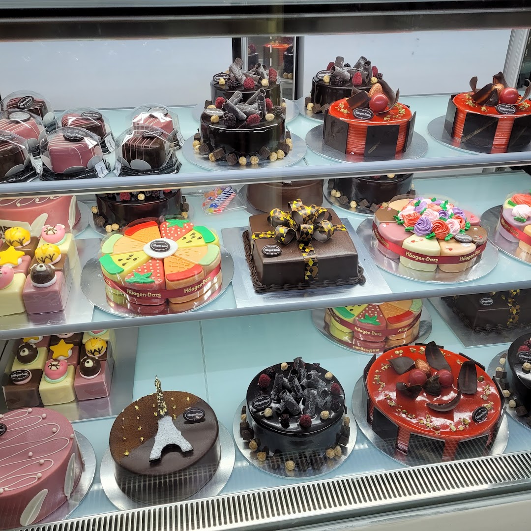 A display case filled with an assortment of Häagen-Dazs ice cream cakes and desserts.