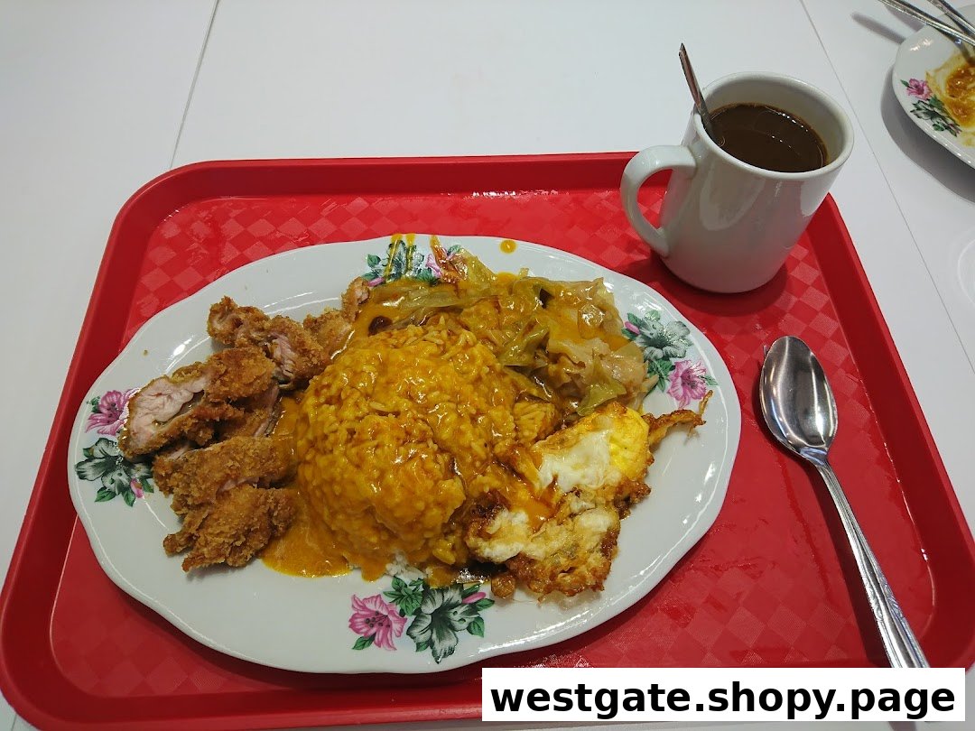 A hearty plate of Hainanese curry rice with crispy fried chicken, fried egg, and cabbage, served with a hot drink.