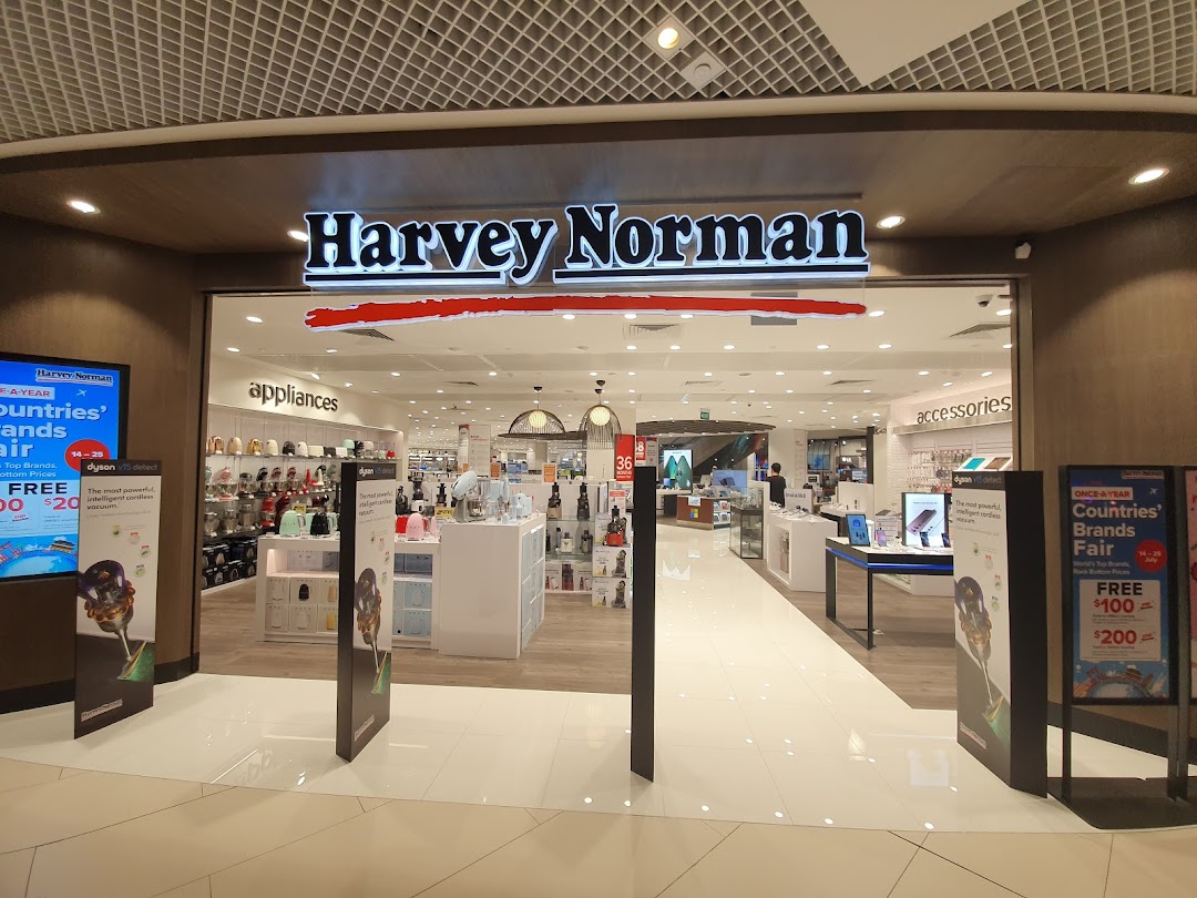 The brightly lit entrance of Harvey Norman, showcasing appliances and accessories, with promotional displays.