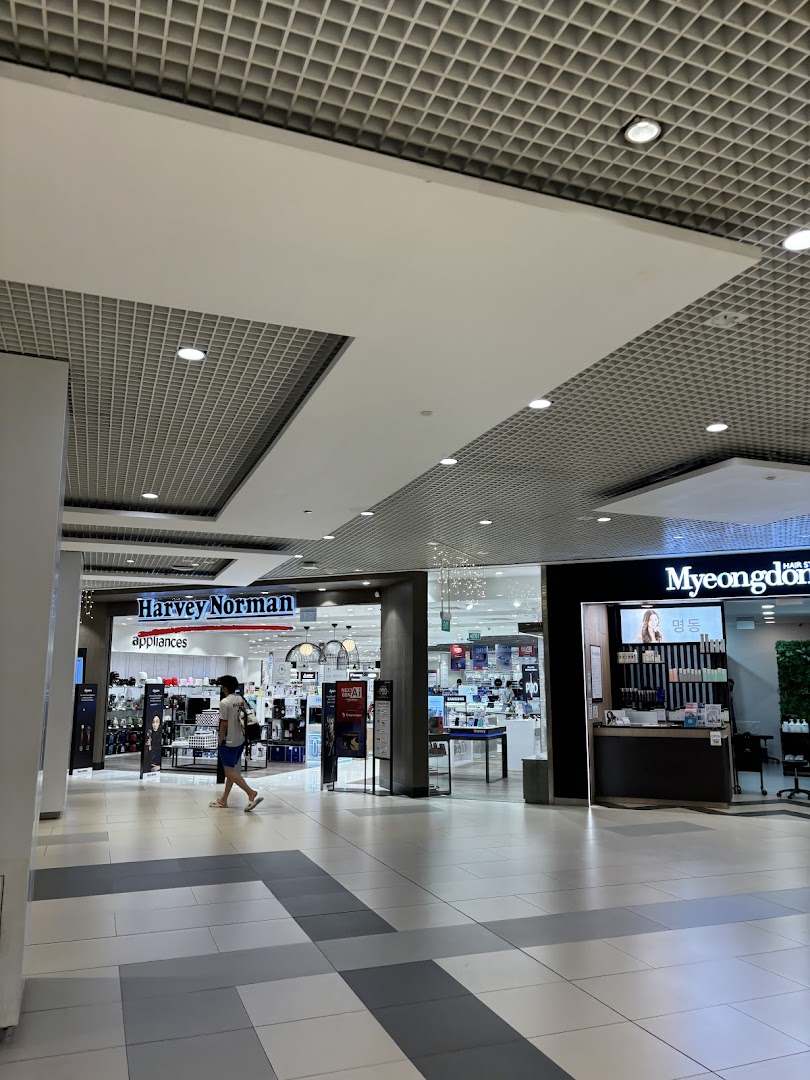 The entrance of Harvey Norman Appliances and Myeongdong Hair Style within a shopping mall corridor.