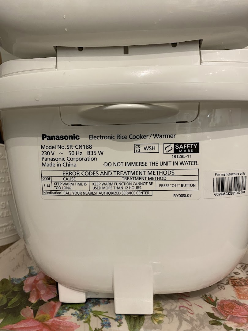 Close-up of a Panasonic electronic rice cooker/warmer label showing model details and error codes.