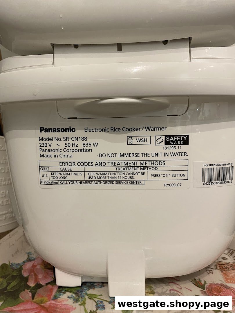 Close-up of a Panasonic electronic rice cooker/warmer label showing model details and error codes.