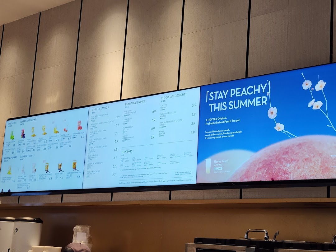 Digital menu boards displaying a variety of tea, fruit drinks, and ice cream options with prices.