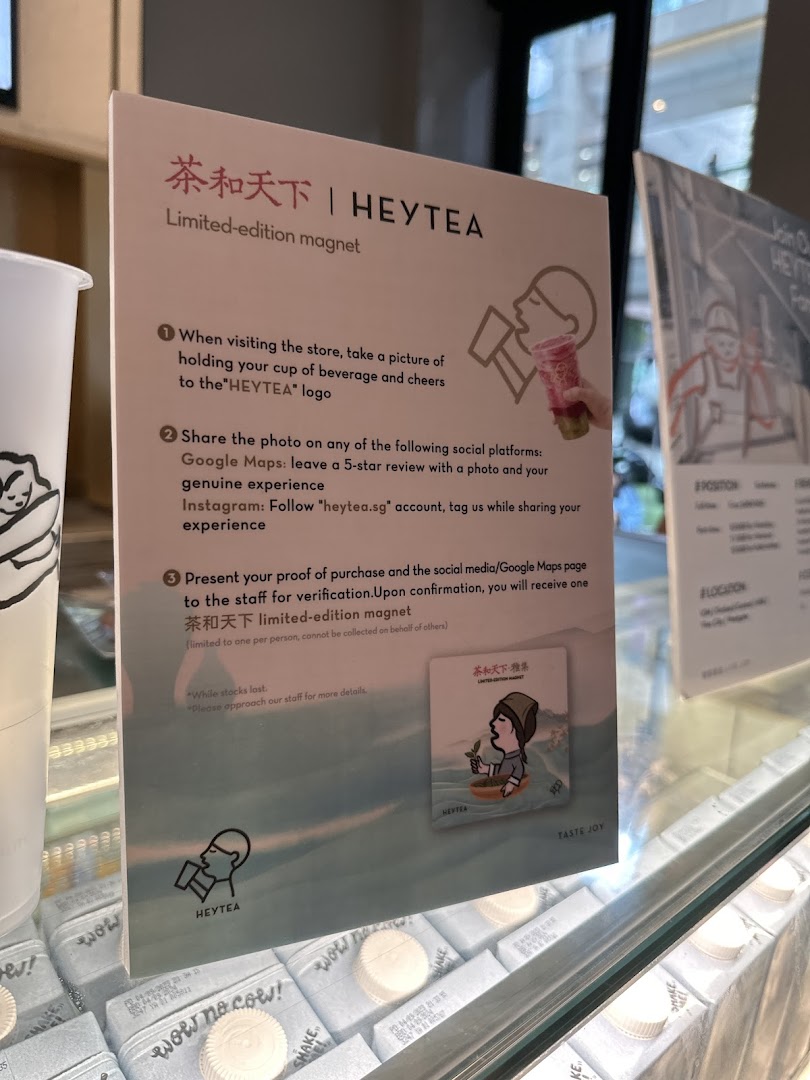 A HEYTEA promotional sign detailing how to get a limited-edition magnet through social media engagement.