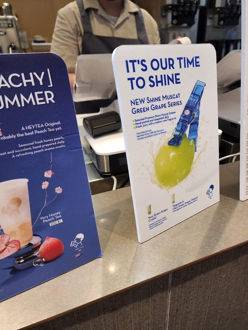 Promotional displays at HEYTEA featuring seasonal peach tea and new green grape series drinks.