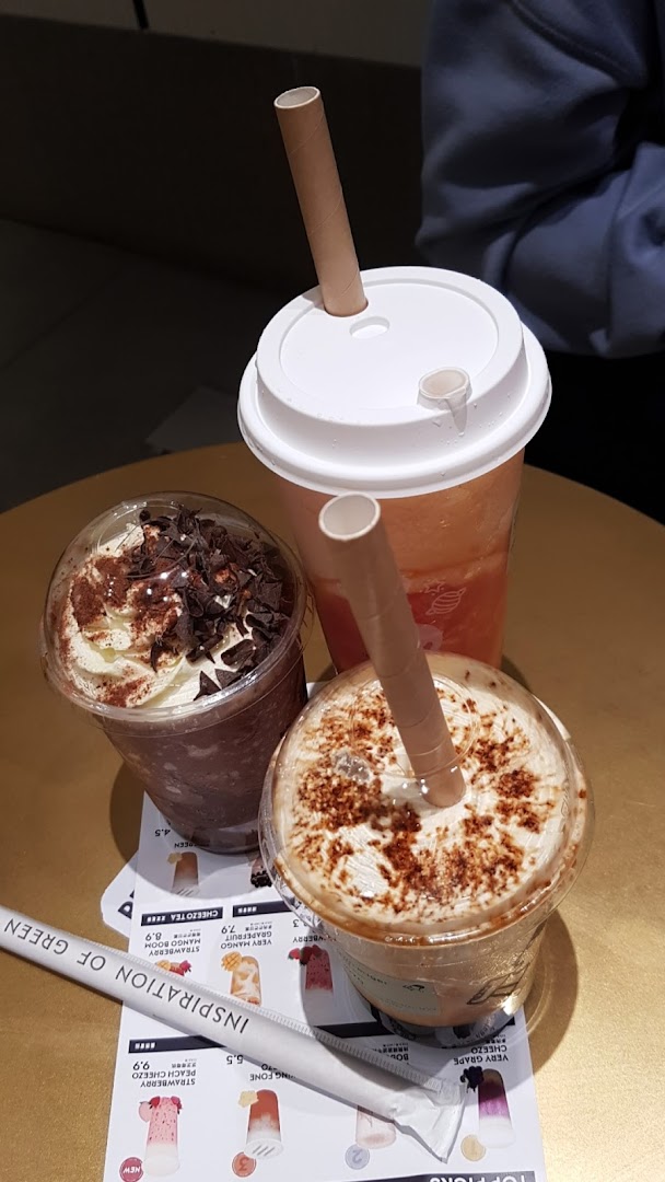 Three refreshing HEYTEA beverages with paper straws on a table, showcasing various flavors.
