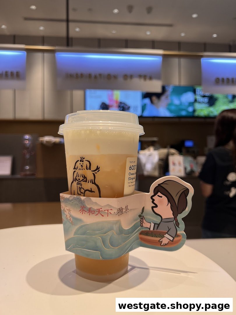 A HEYTEA cheese foam tea drink with a decorative sleeve on a counter inside the shop.