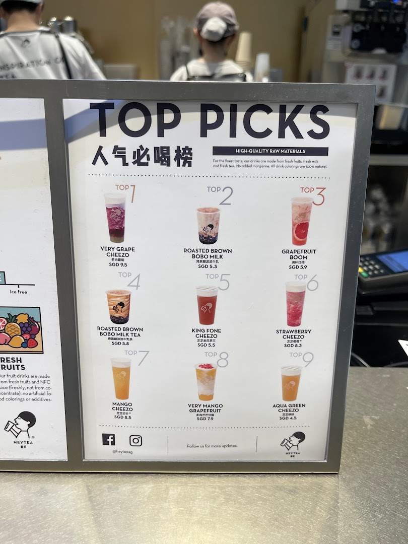 A display board showcasing HEYTEA's 'Top Picks' menu with various fruit and milk tea beverages.