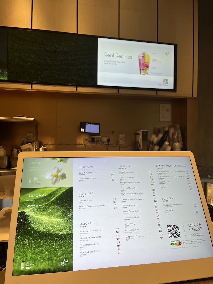 A digital menu display at HEYTEA showcasing various tea, fruit, and matcha beverages with prices.