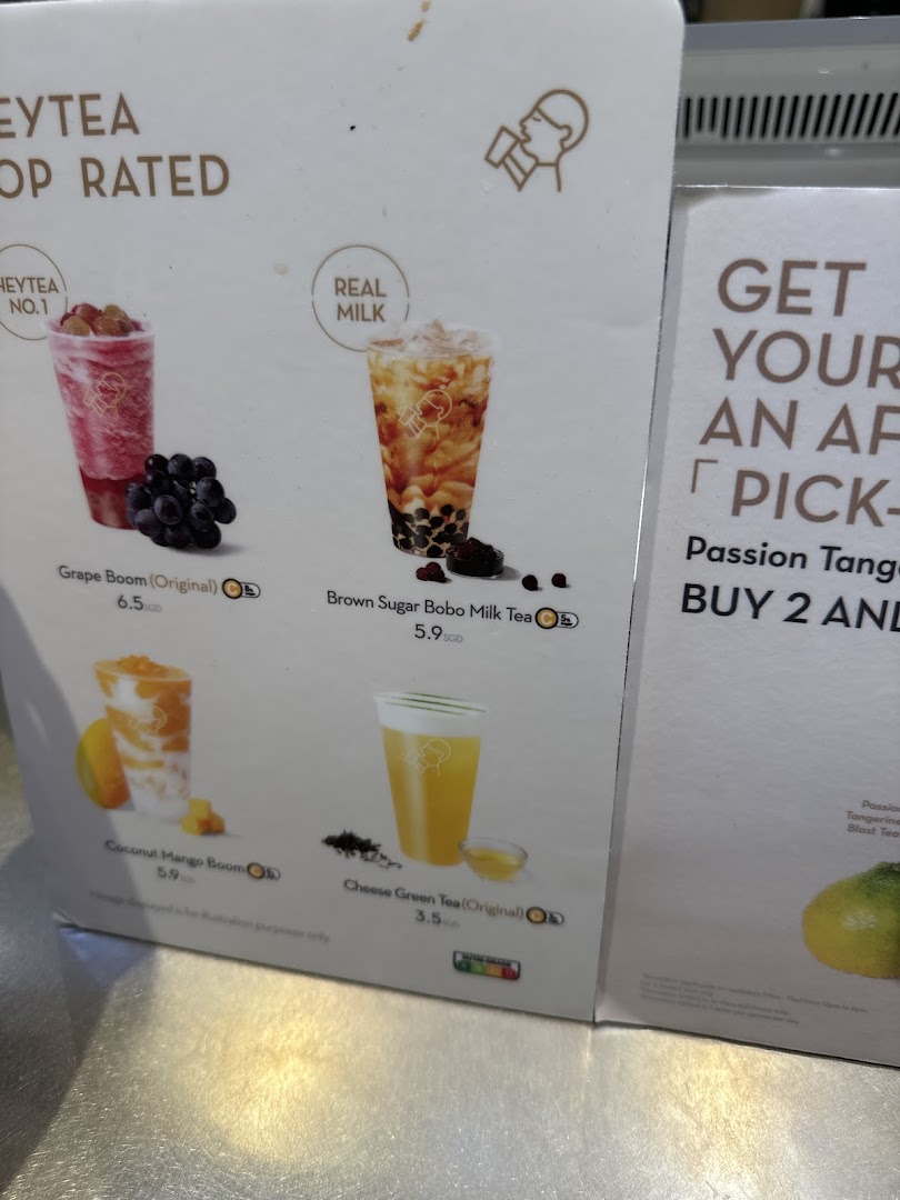 A close-up of HEYTEA's menu board displaying popular fruit teas, milk teas, and cheese tea options with prices.