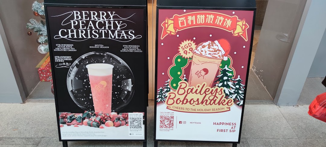 Two A-frame signs promoting HEYTEA's festive 'Berry Peachy Christmas' and 'Baileys Boboshake' drinks.