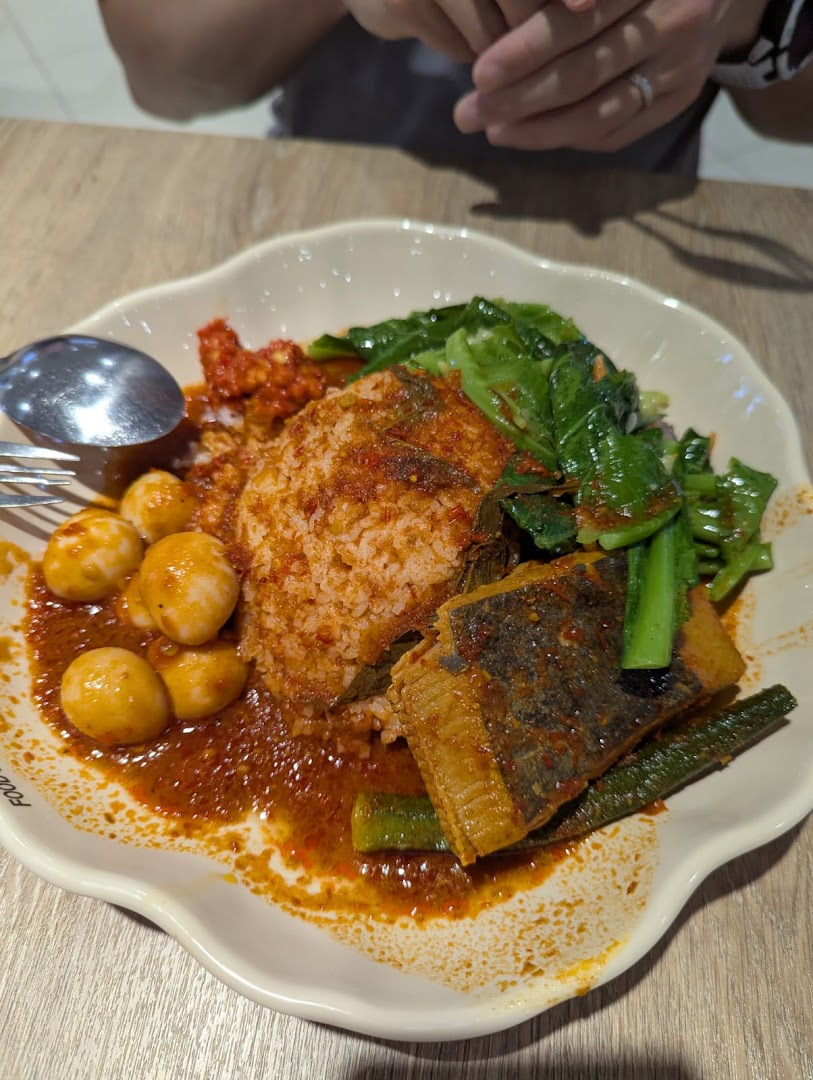 A vibrant plate of spicy rice with fish, vegetables, and quail eggs, showcasing a delicious meal.