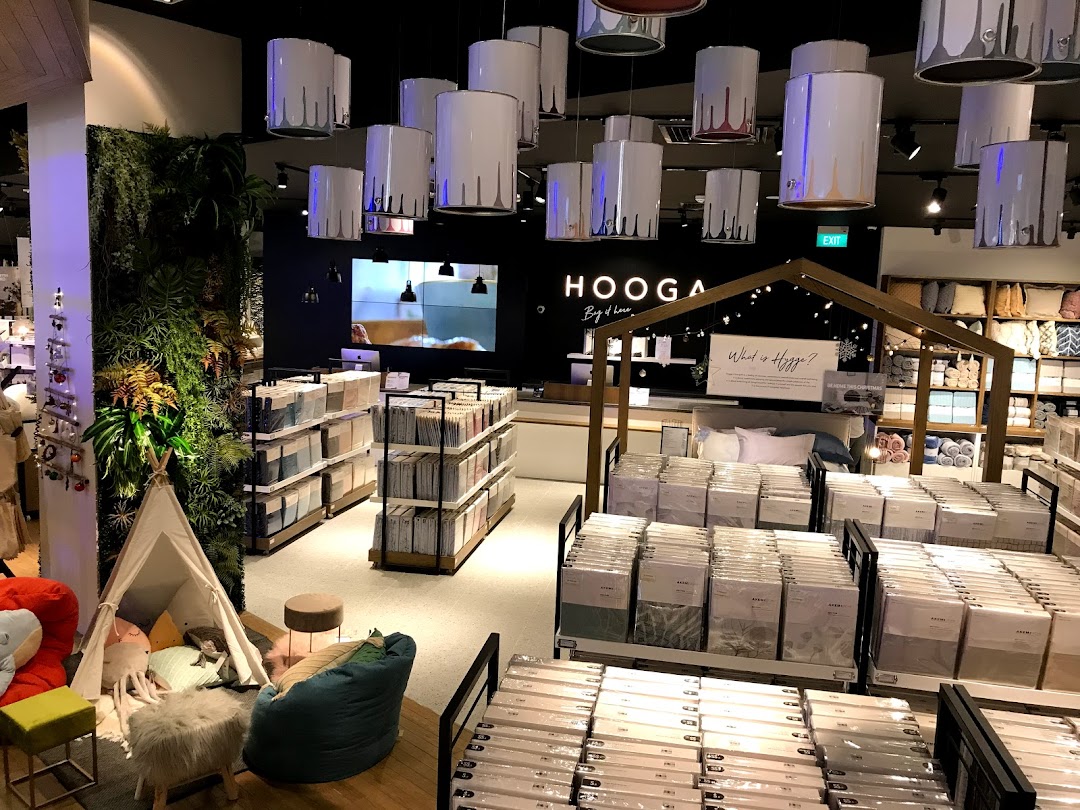Interior view of HOOGA store showcasing home decor, bedding, and a cozy children's play area.