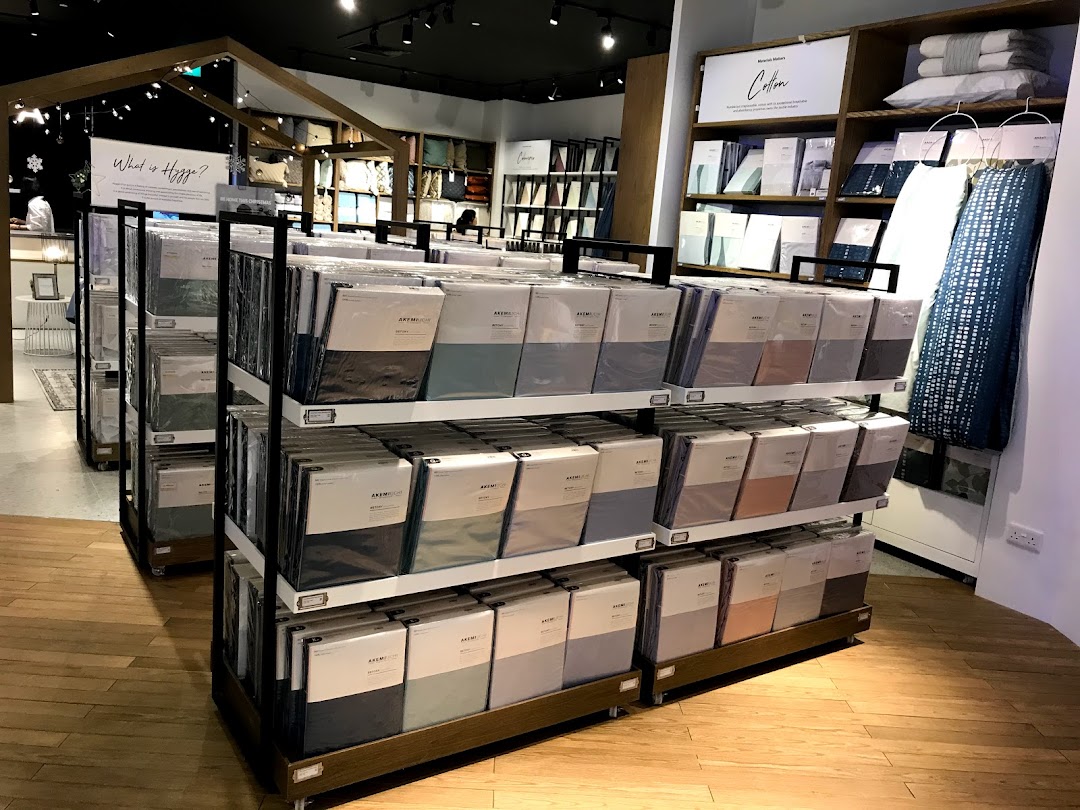 Interior view of HOOGA Westgate, showcasing neatly arranged bedding and home textile products in a warm, inviting setting.