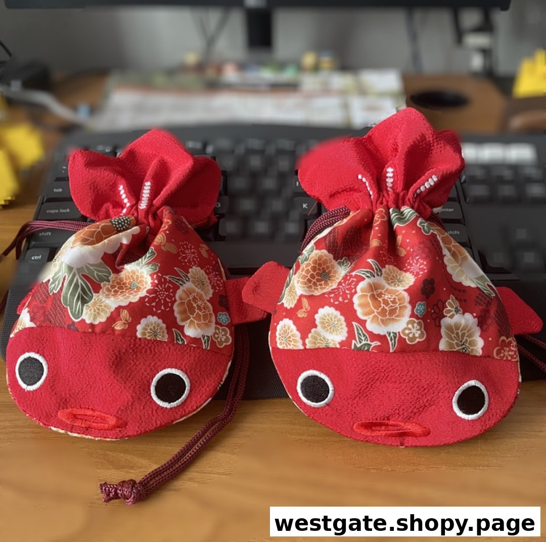 Two charming red fish-shaped pouches with floral patterns, likely decorative items or gifts.